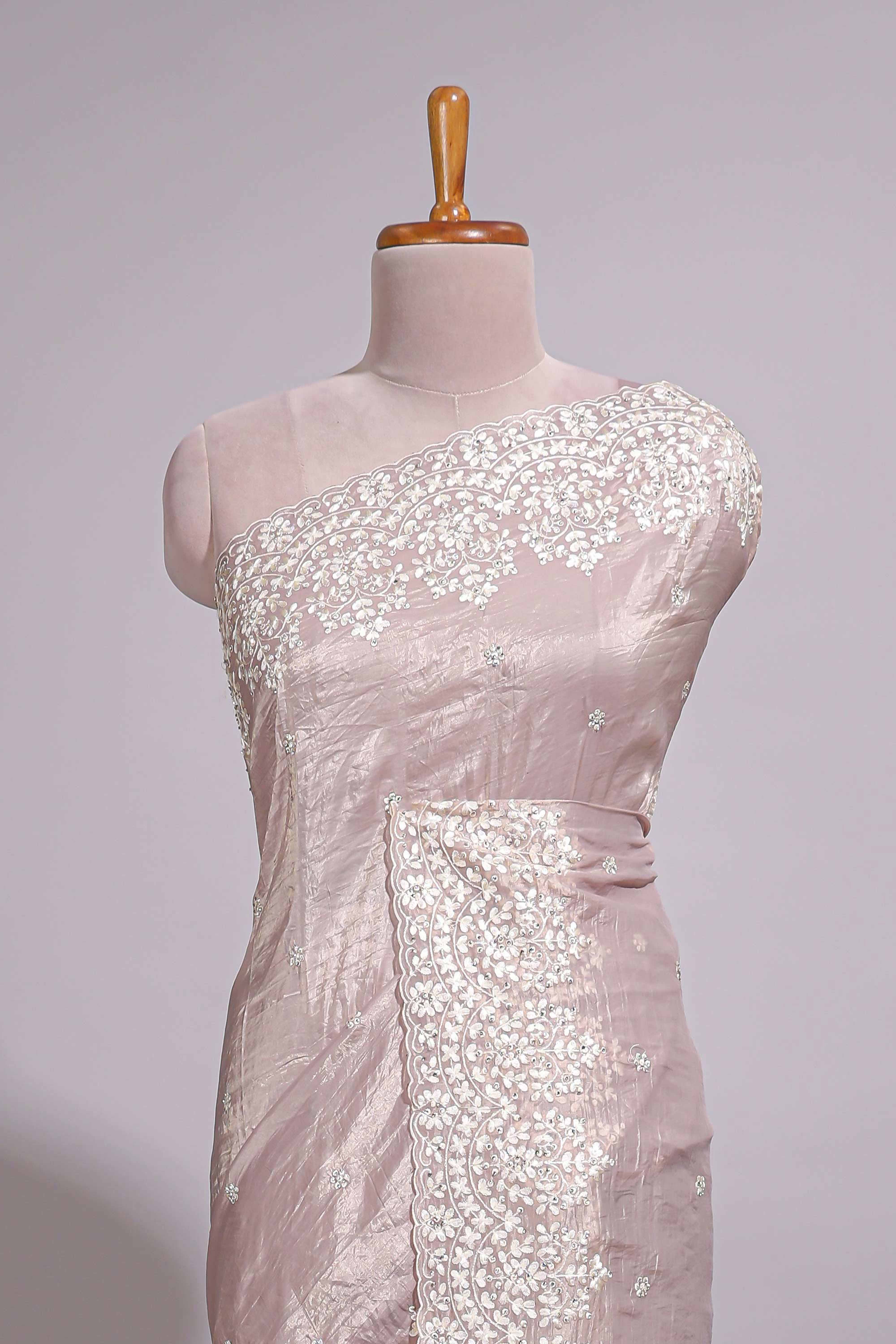 Soft blush pink organza saree with delicate floral embroidery intricate lace border and scalloped pallu detailing
