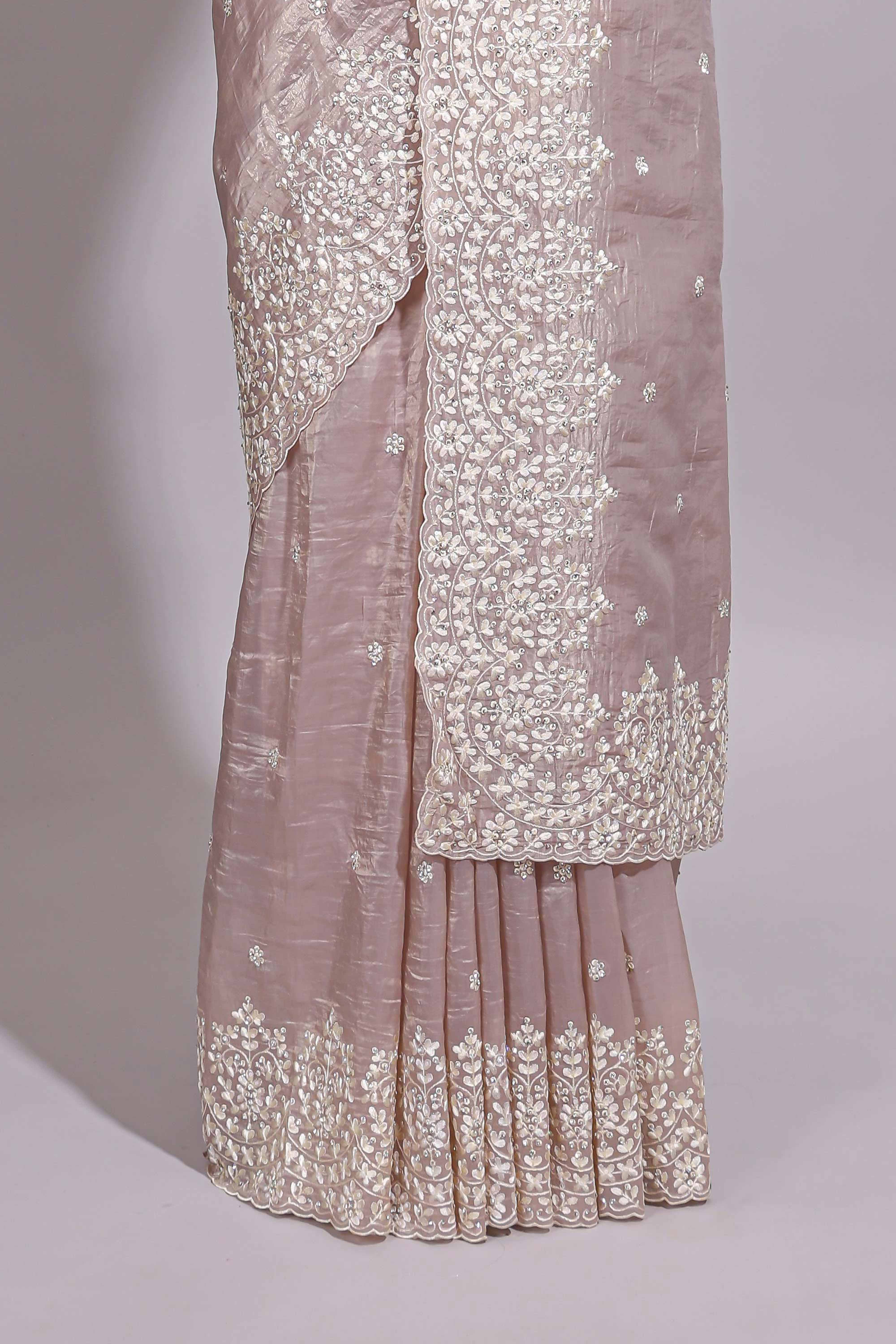 Soft blush pink organza saree with delicate floral embroidery intricate lace border and scalloped pallu detailing