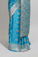 Blue shade floral designed banarasi silk saree with self zari border and blouse