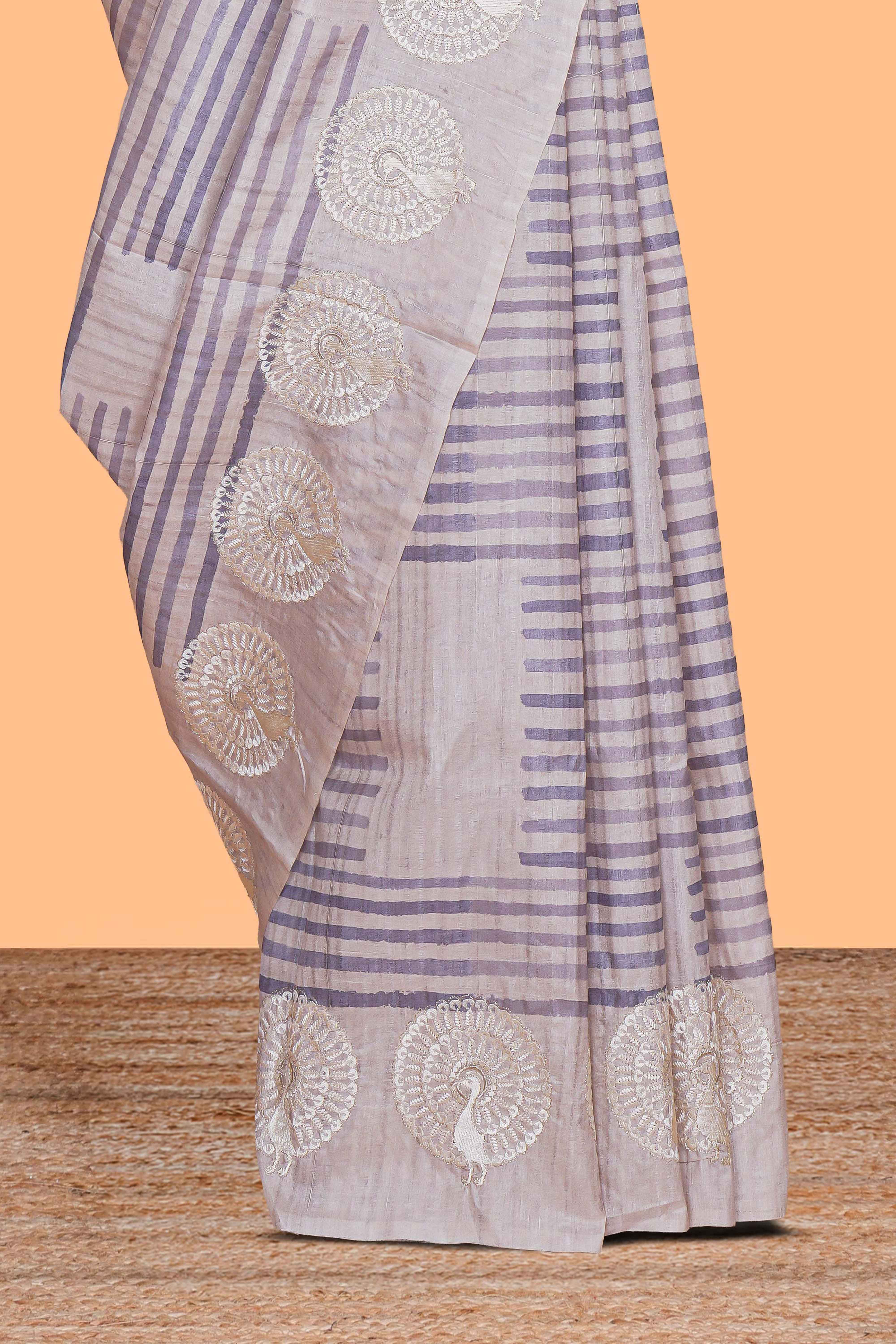 Off white striped design raw silk saree with self peacock design embroidery border and matching checked blouse