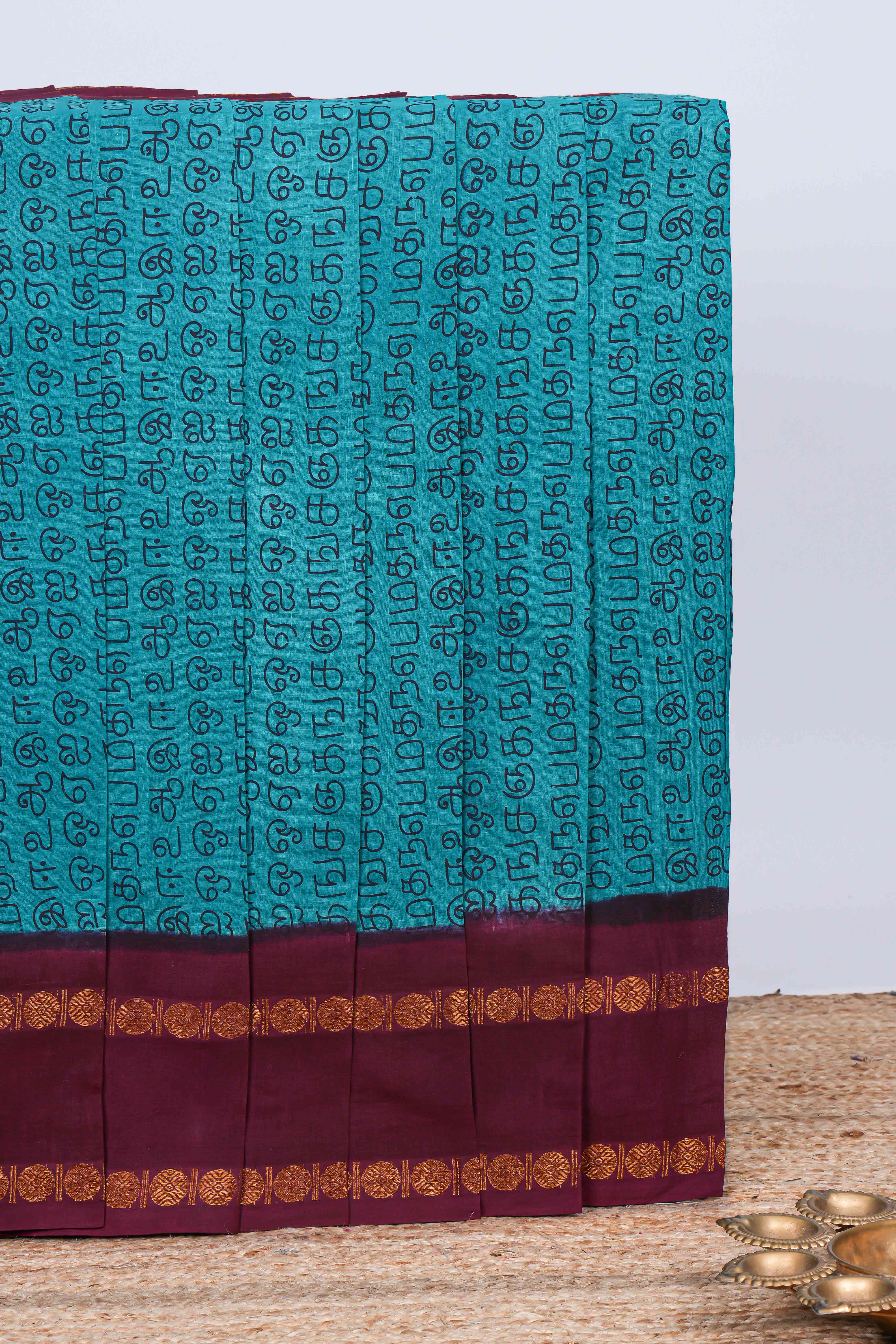 Turquiose blue tamil script print sungudi cotton saree with contrast zari bentex border and pallu