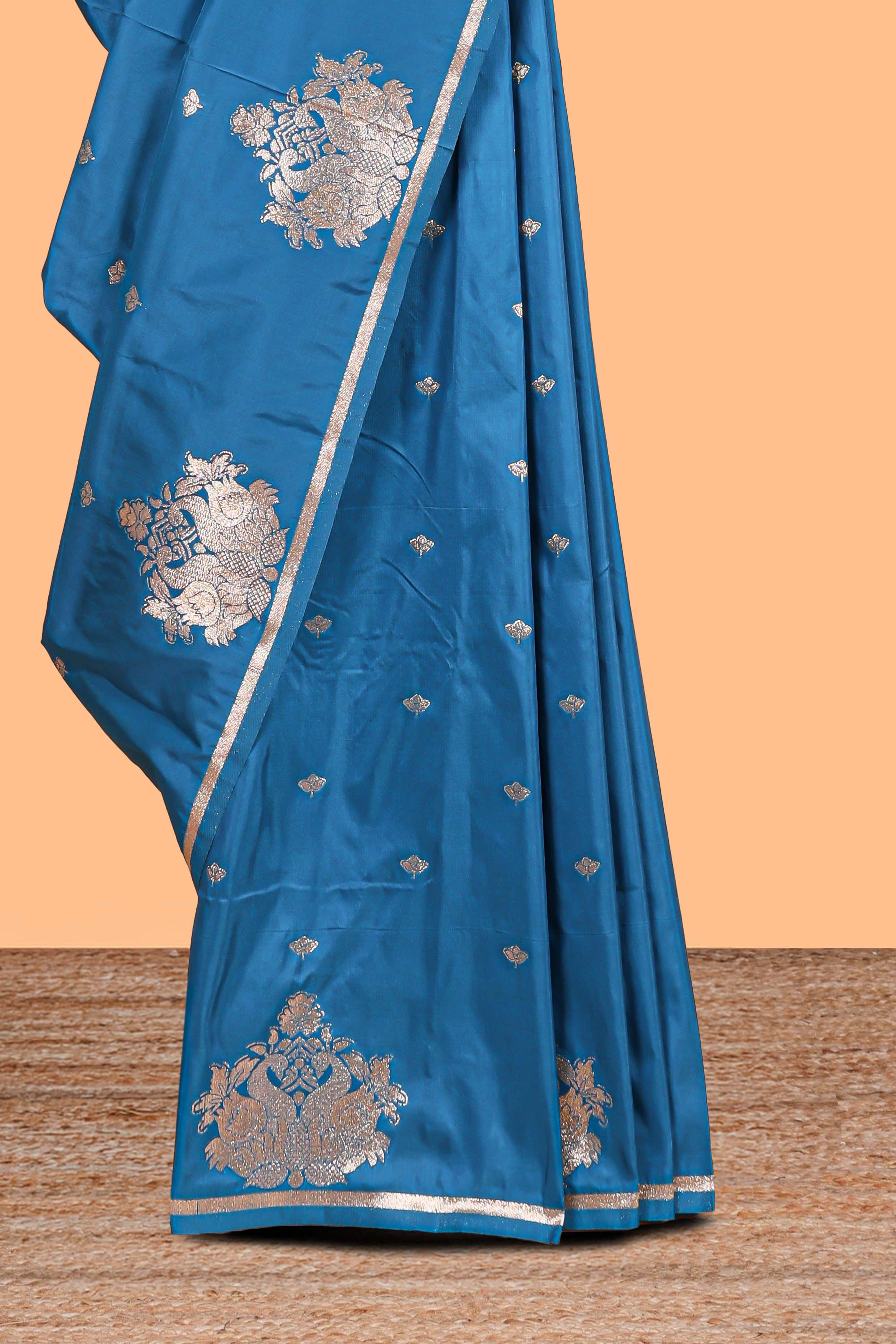 Blue colour Semi soft silk withgold zari floral motifs border with peacock motifs and matching blouse