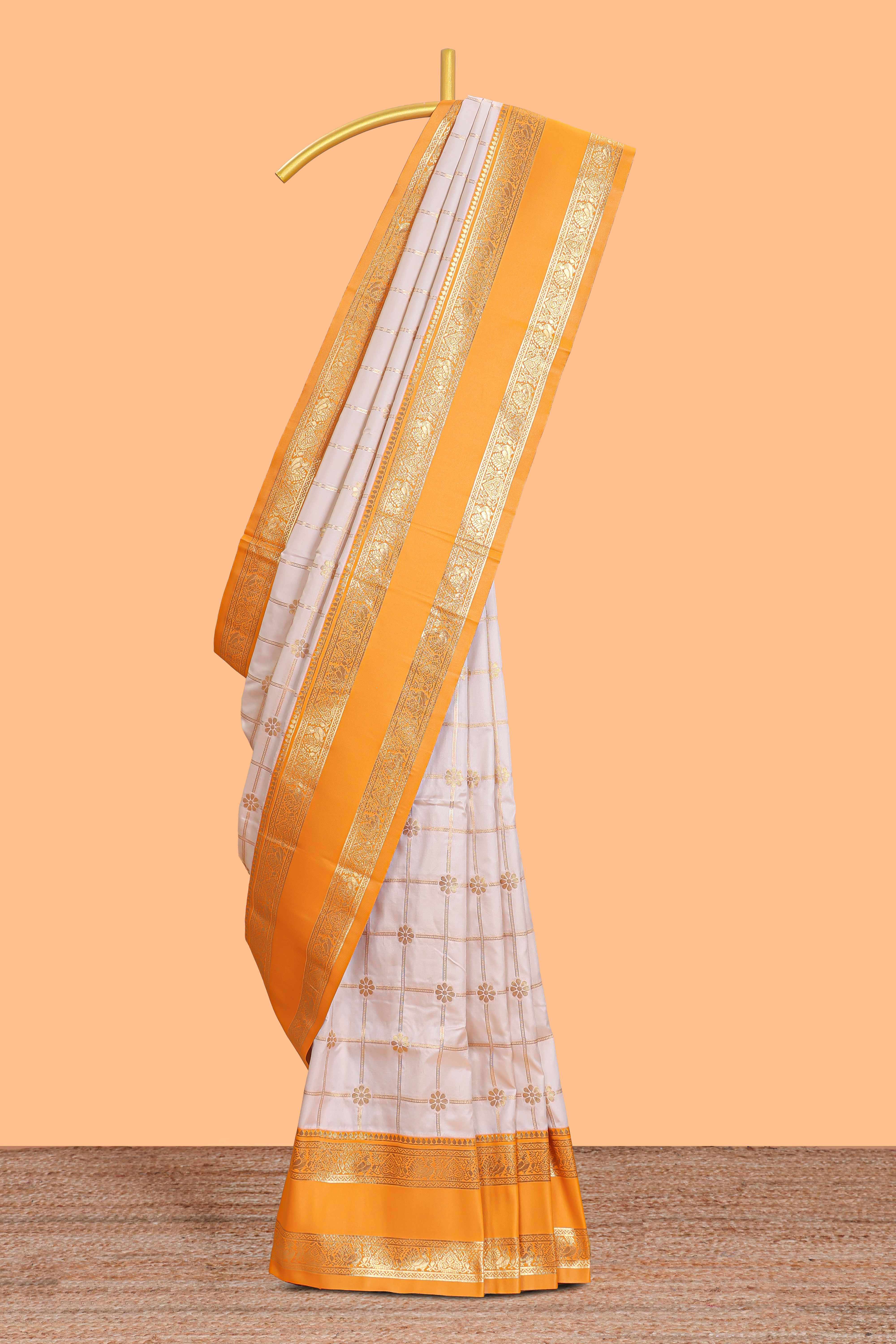 Cream checked floral zari design semi soft silk saree with contrast bentex border and floral motifs blouse