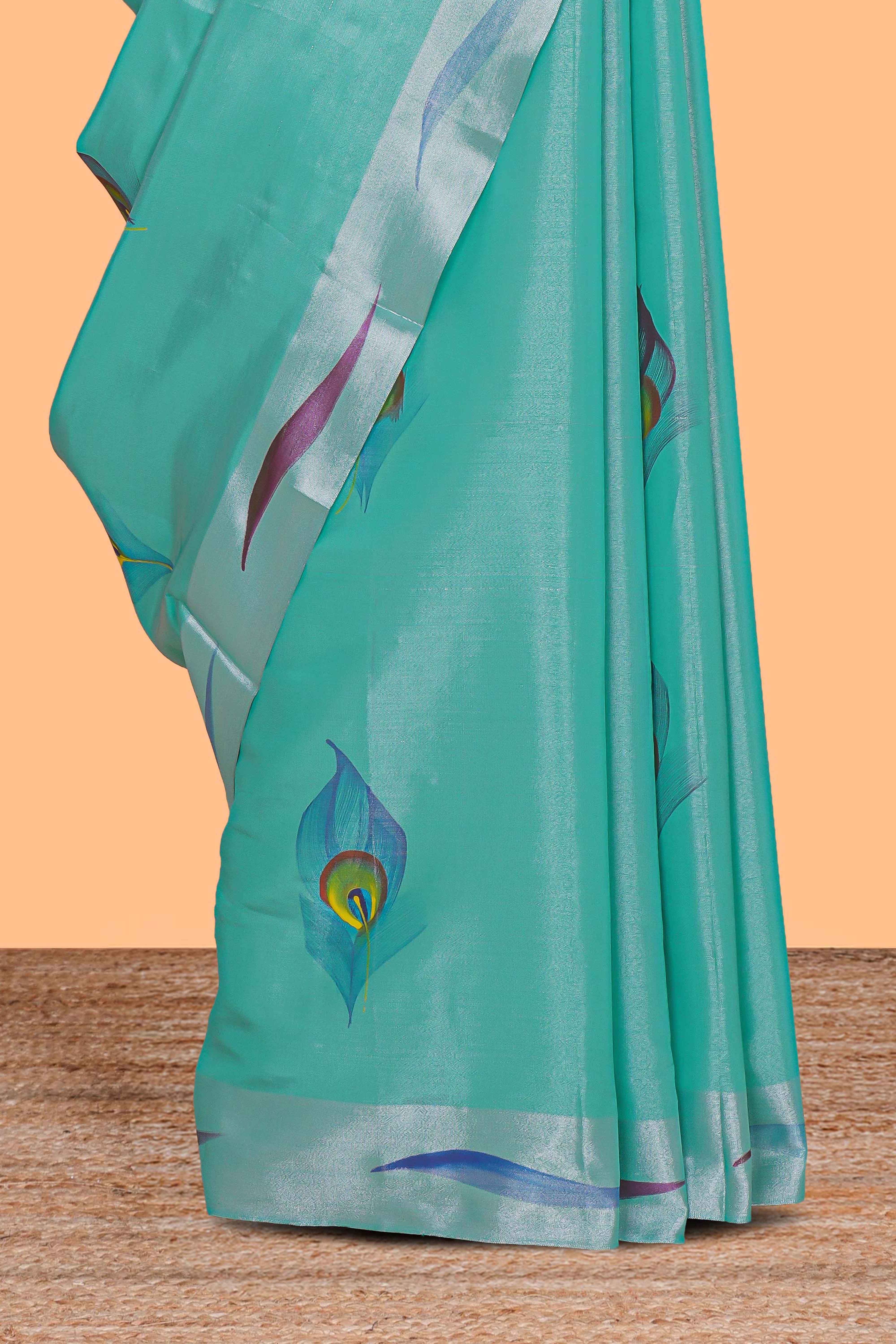 Teal green peacock feather design tissue saree with self zari border and contrast blouse