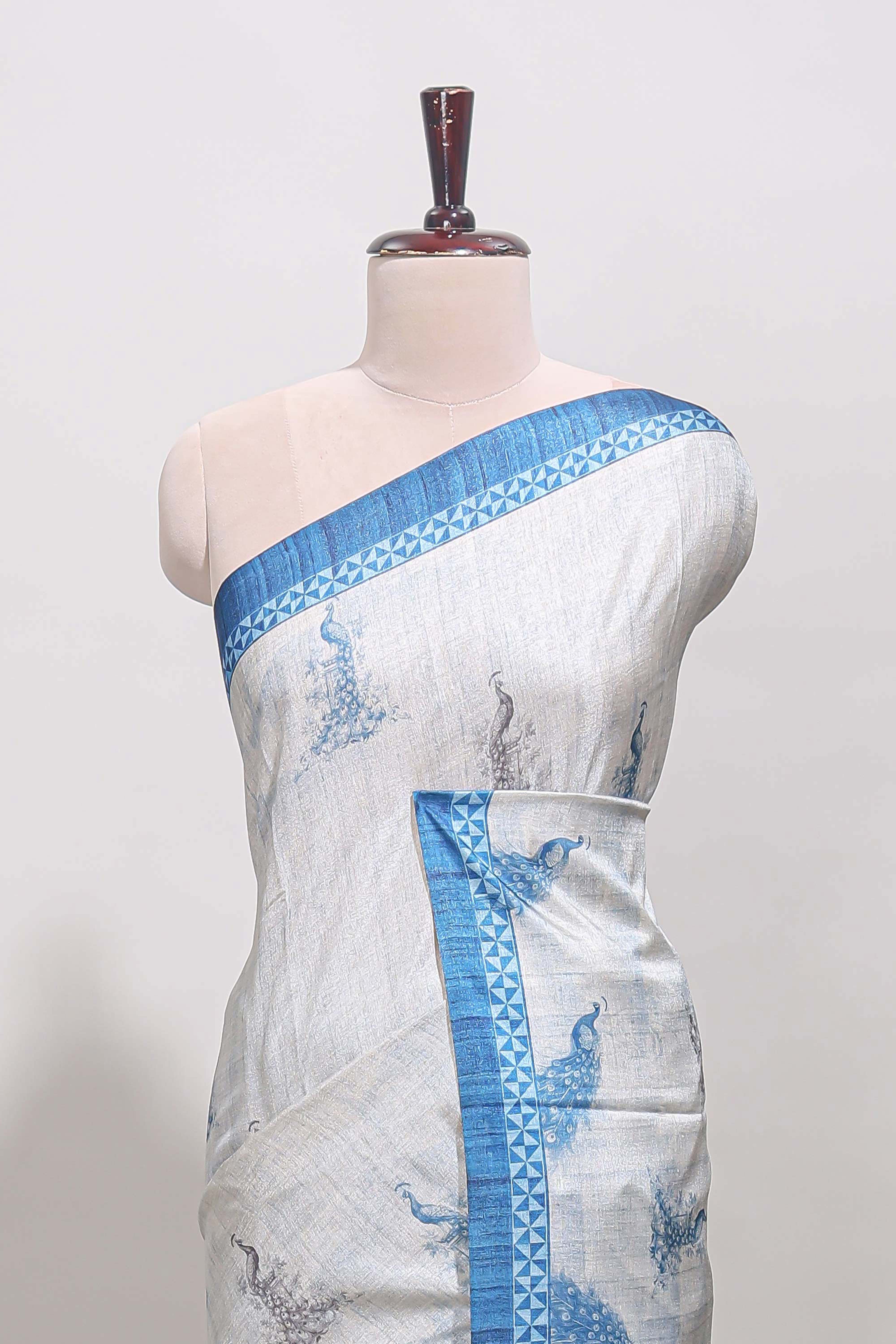 Cream peacock motifs tussar saree with contrast blue border and peacock printed pallu