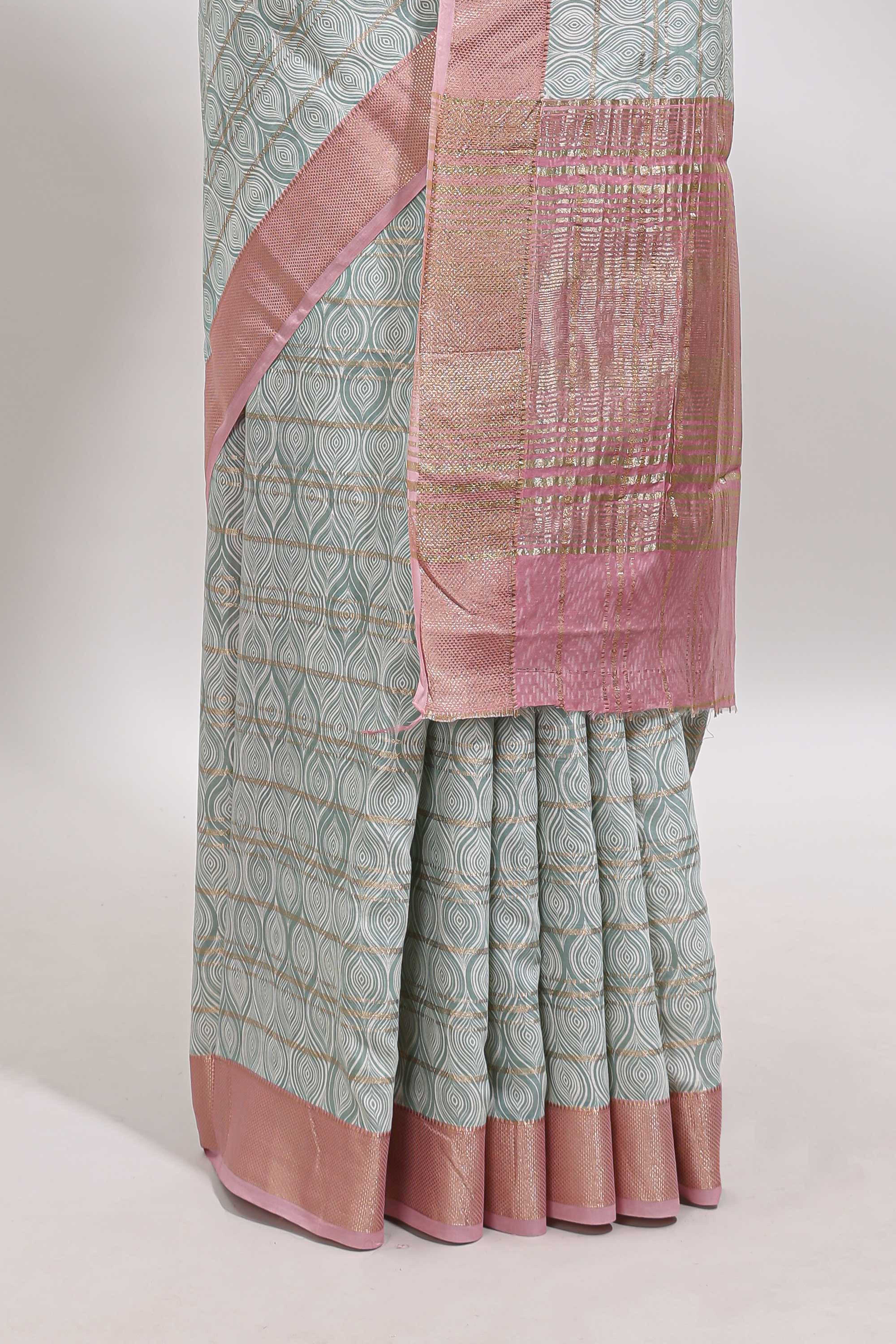 Green geometric design tussar saree with contrast zari border and striped blouse