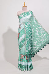 Green Tussar saree with a floral body featuring bird motifs a printed pallu with tassels and a matchingfloral blouse piece