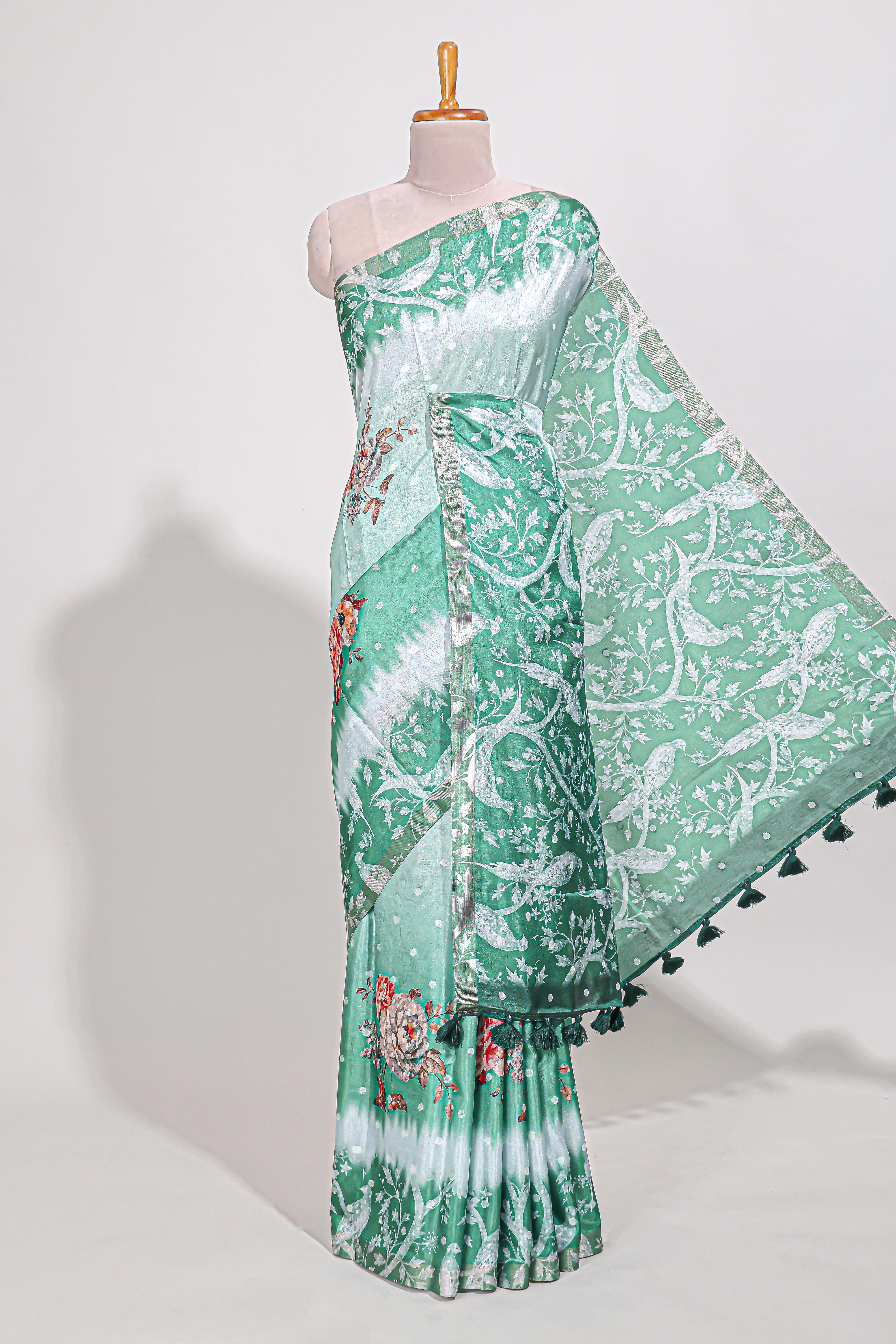 Green Tussar saree with a floral body featuring bird motifs a printed pallu with tassels and a matchingfloral blouse piece