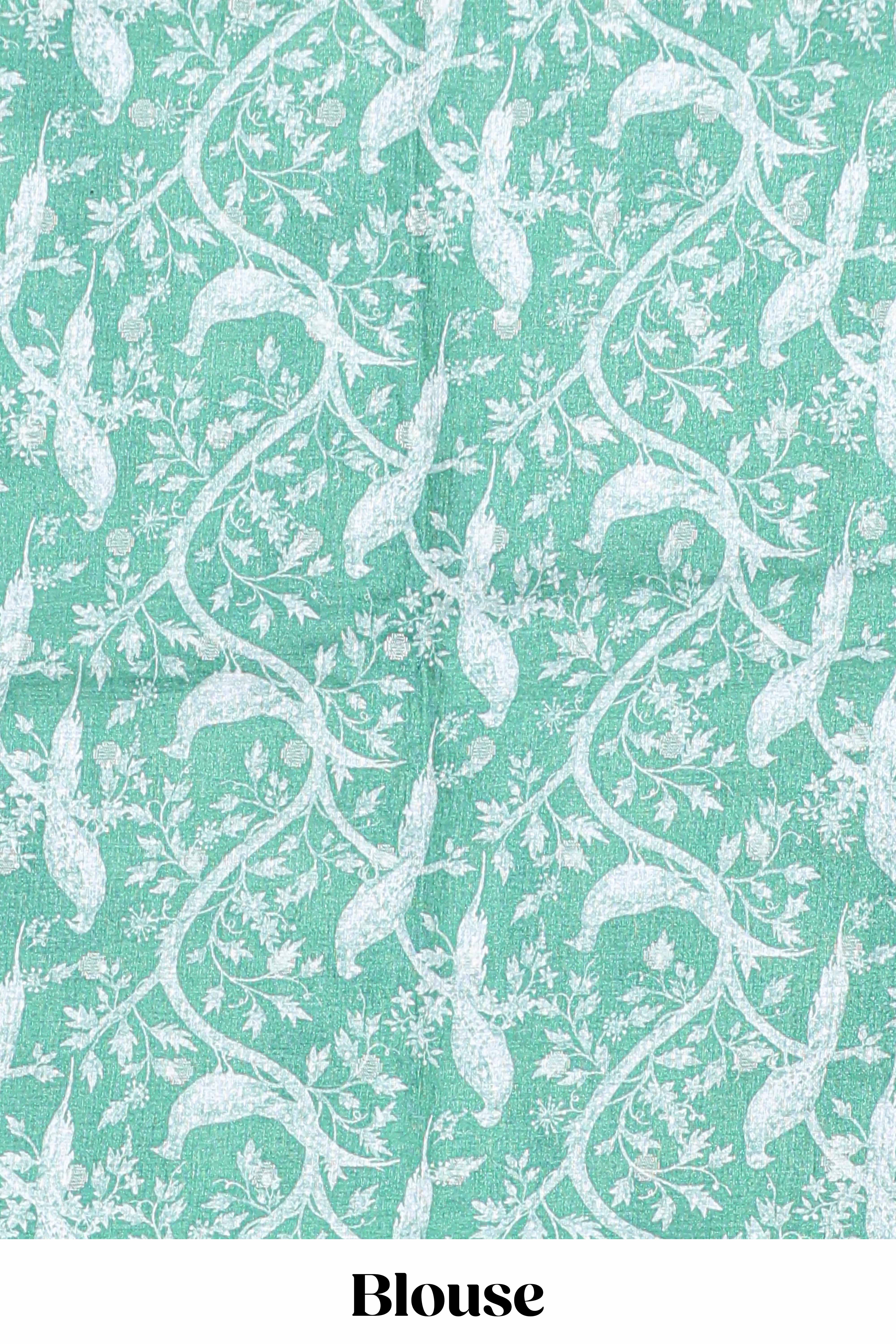 Green Tussar saree with a floral body featuring bird motifs a printed pallu with tassels and a matchingfloral blouse piece