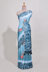 Blue Tussar saree with a floral body featuring bird motifs a printed pallu with tassels and a matchingfloral blouse piece