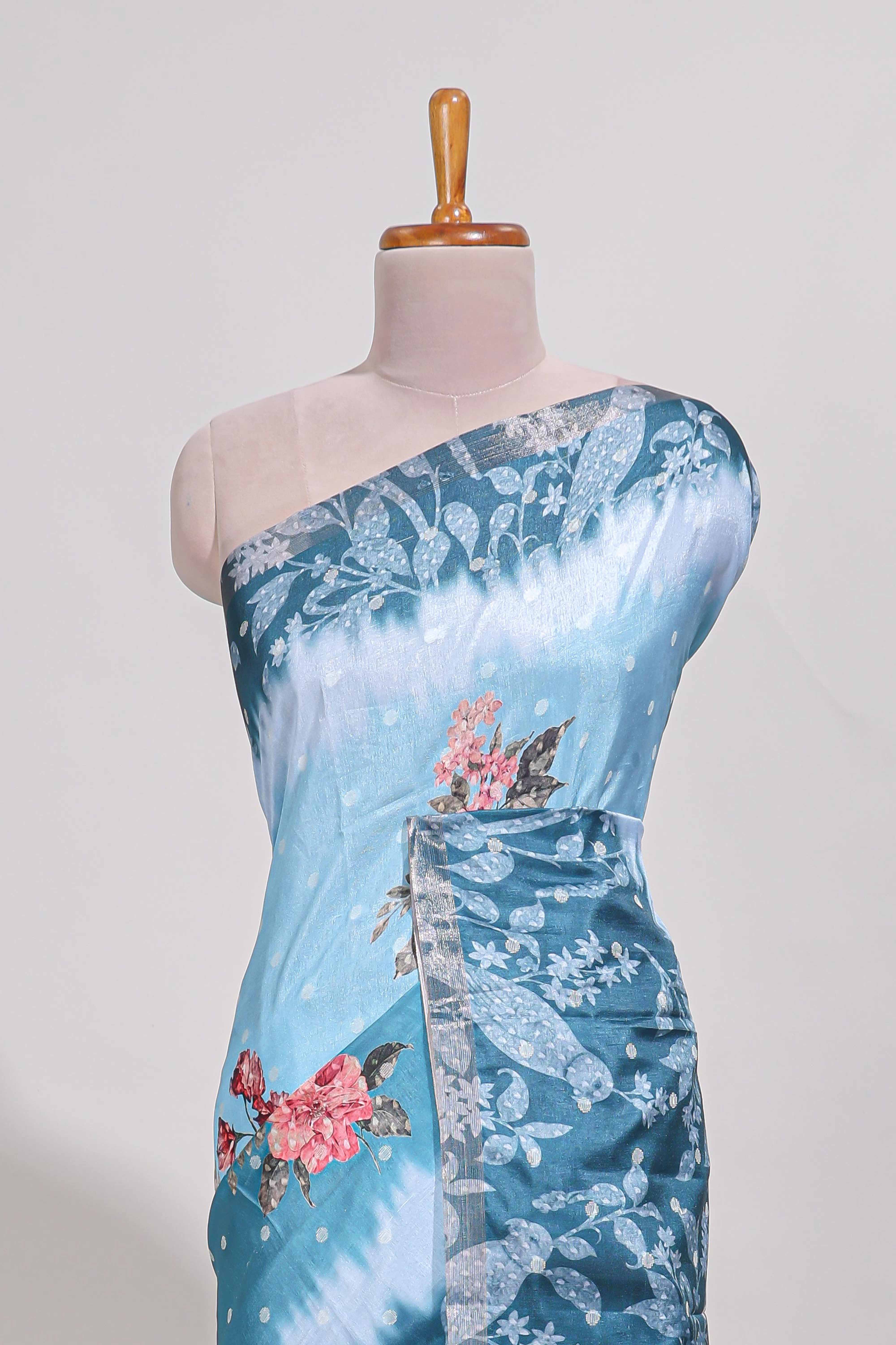 Blue Tussar saree with a floral body featuring bird motifs a printed pallu with tassels and a matchingfloral blouse piece