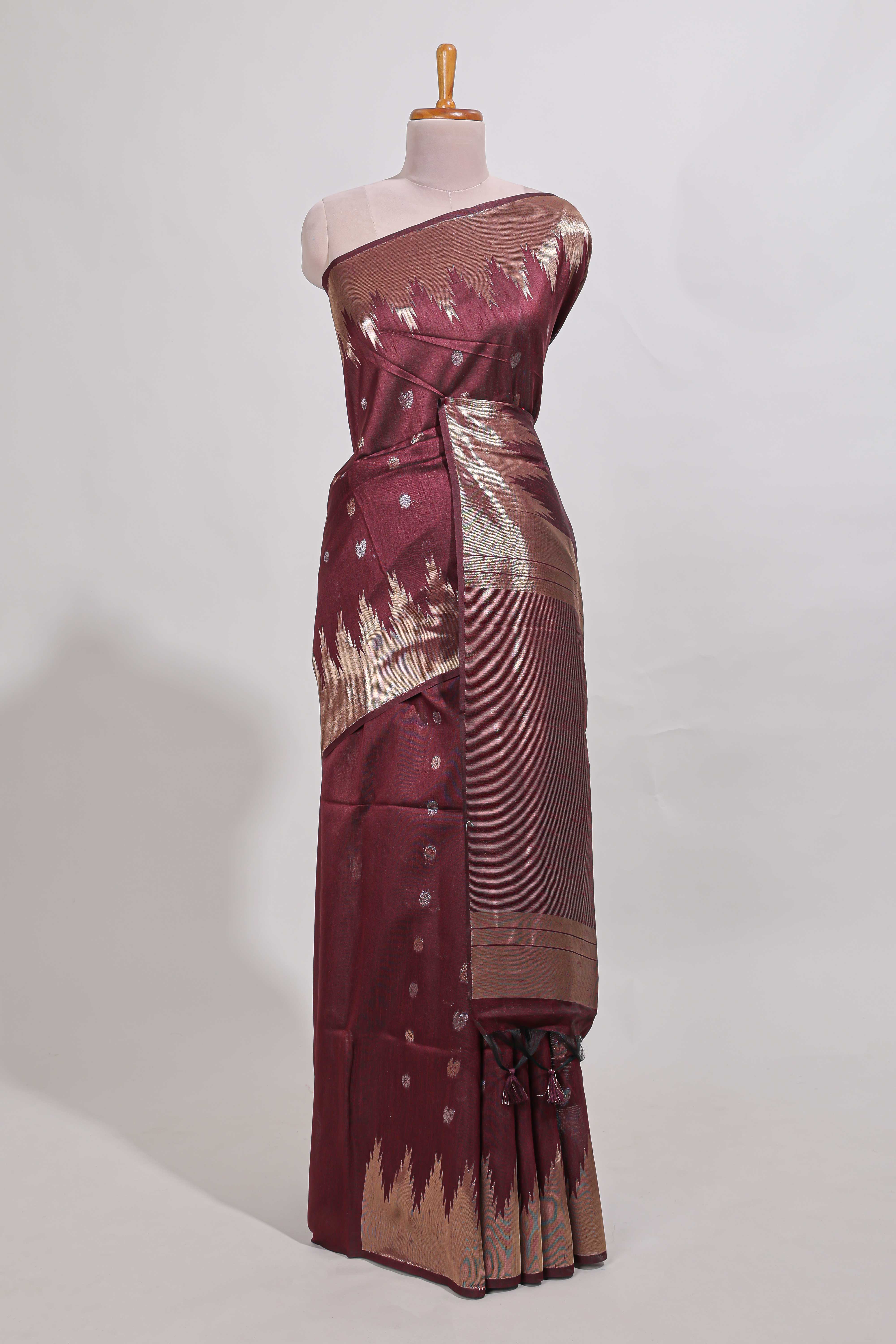 Maroon shimmering zari tussar saree with zari detailing temple pattern borders , and a rich zari pallu