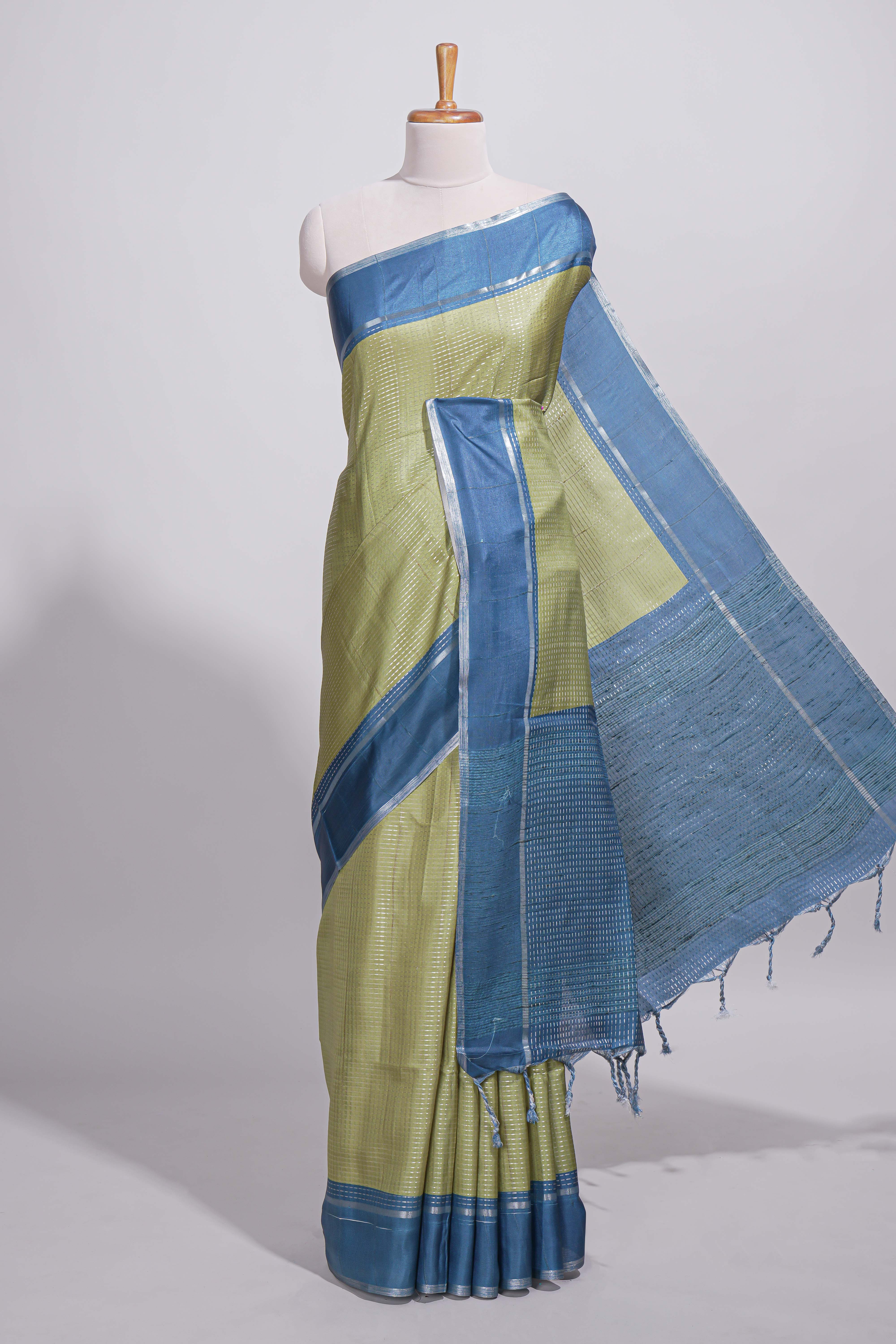Green tussar saree with woven checks by rich blue border and matching zari woven pallu with contrast blouse piece