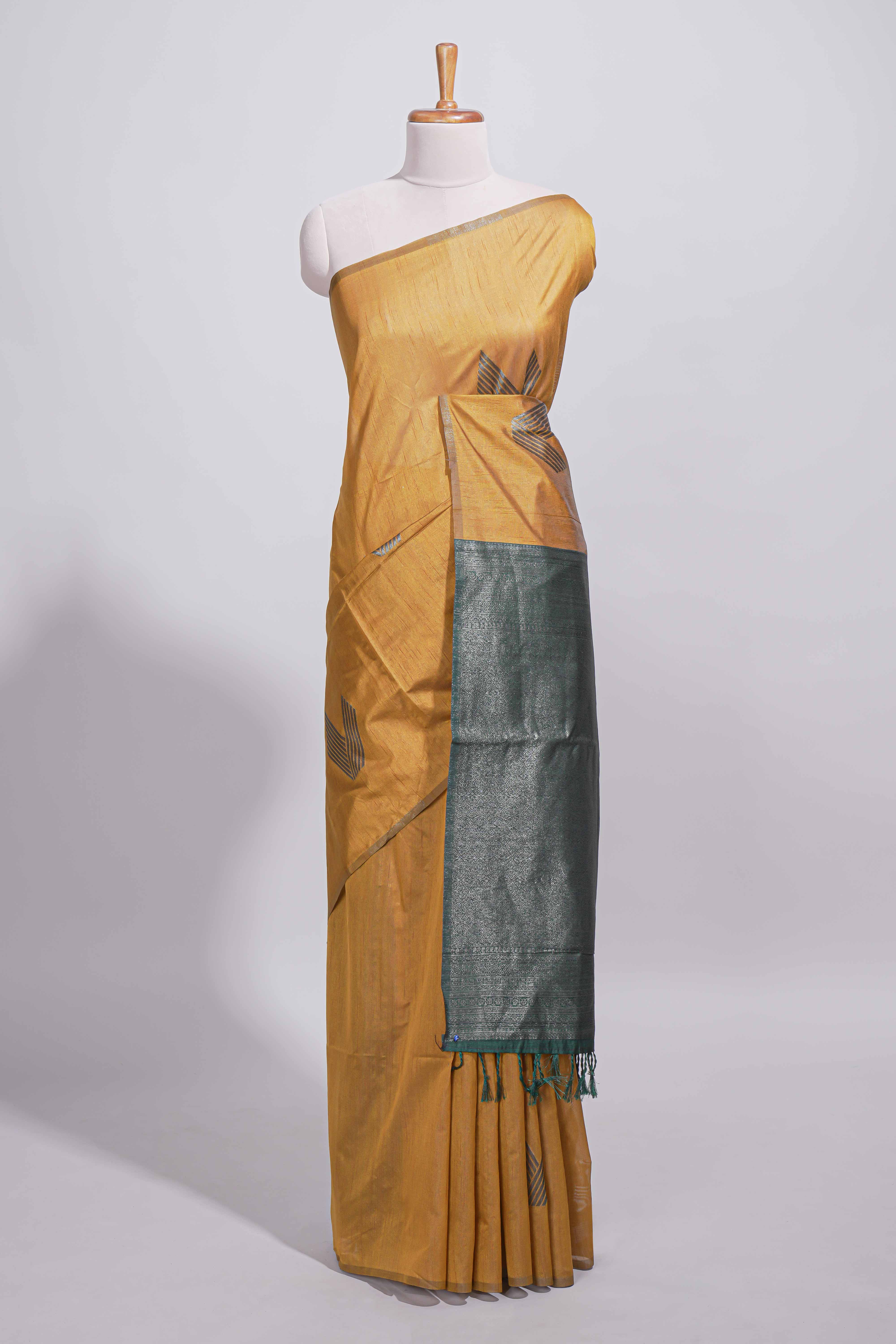 Mustard yellow tussar saree with subtle silver woven motifs paired with a rich zari pallu with tassels with contrast blouse piece