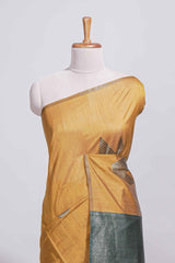 Mustard yellow tussar saree with subtle silver woven motifs paired with a rich zari pallu with tassels with contrast blouse piece
