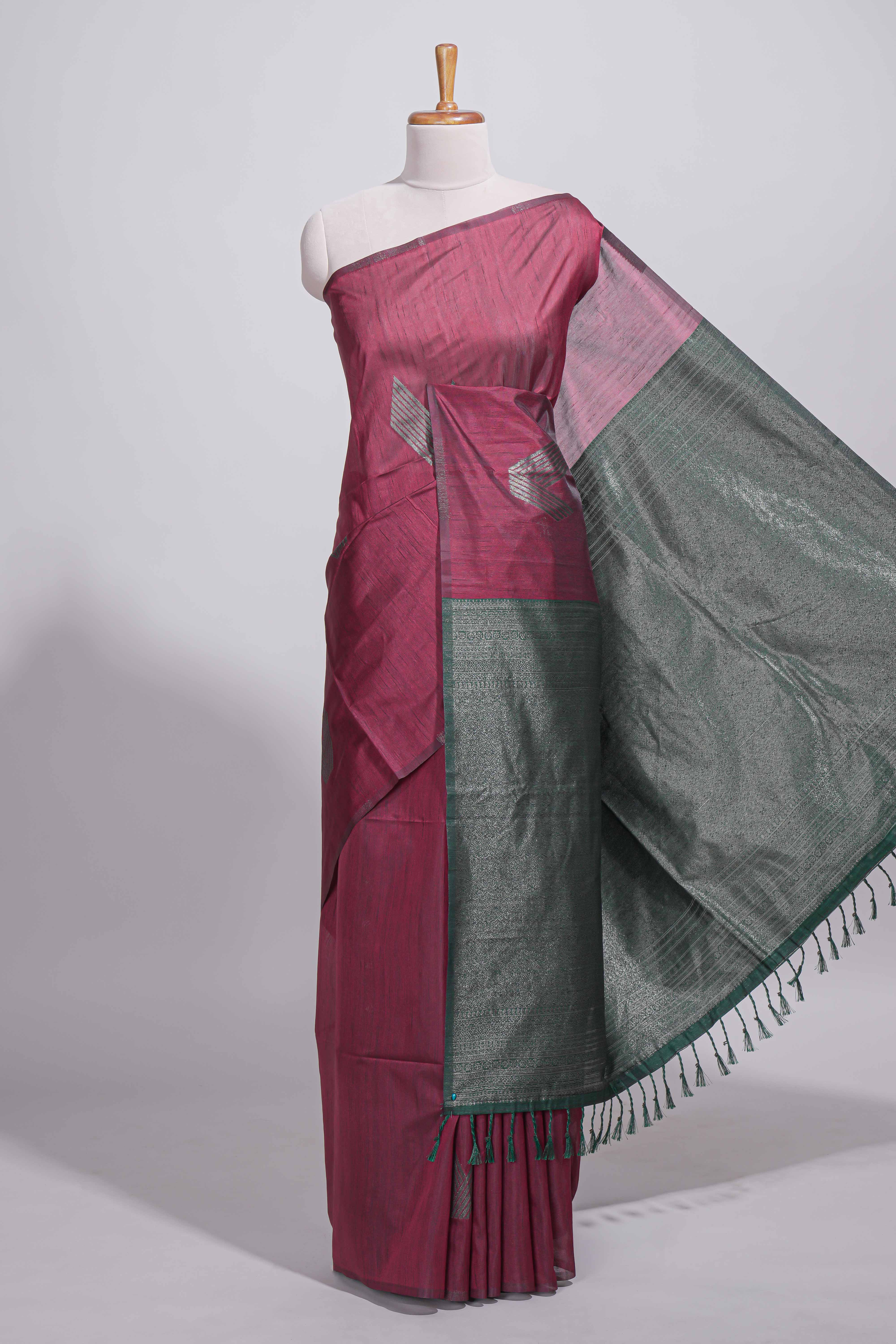 Maroon tussar saree with subtle silver woven motifs paired with a rich zari pallu with tassels with contrast blouse piece