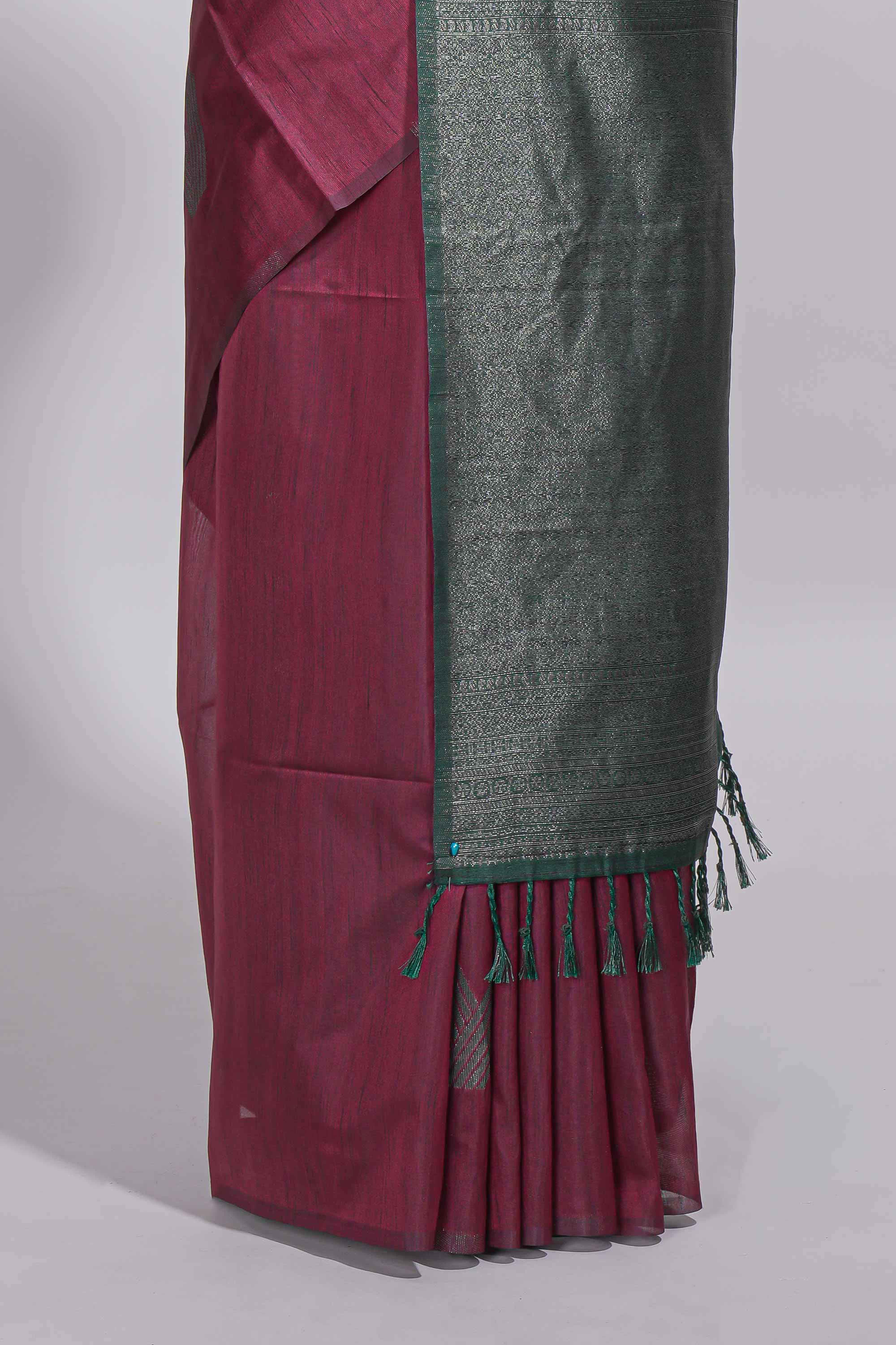 Maroon tussar saree with subtle silver woven motifs paired with a rich zari pallu with tassels with contrast blouse piece