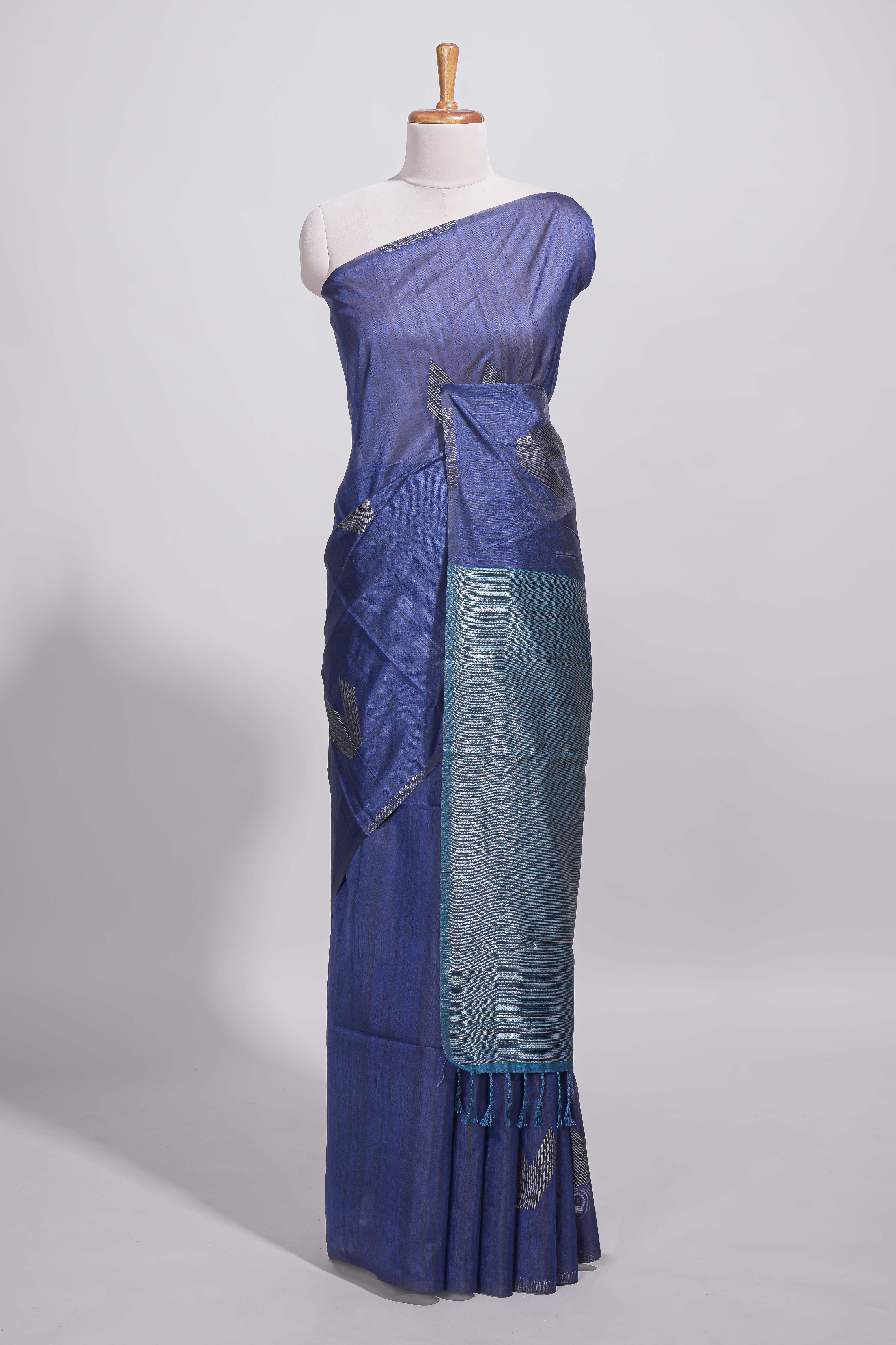 Navy blue tussar saree with subtle silver woven motifs paired with a rich zari pallu with tassels with contrast blouse piece
