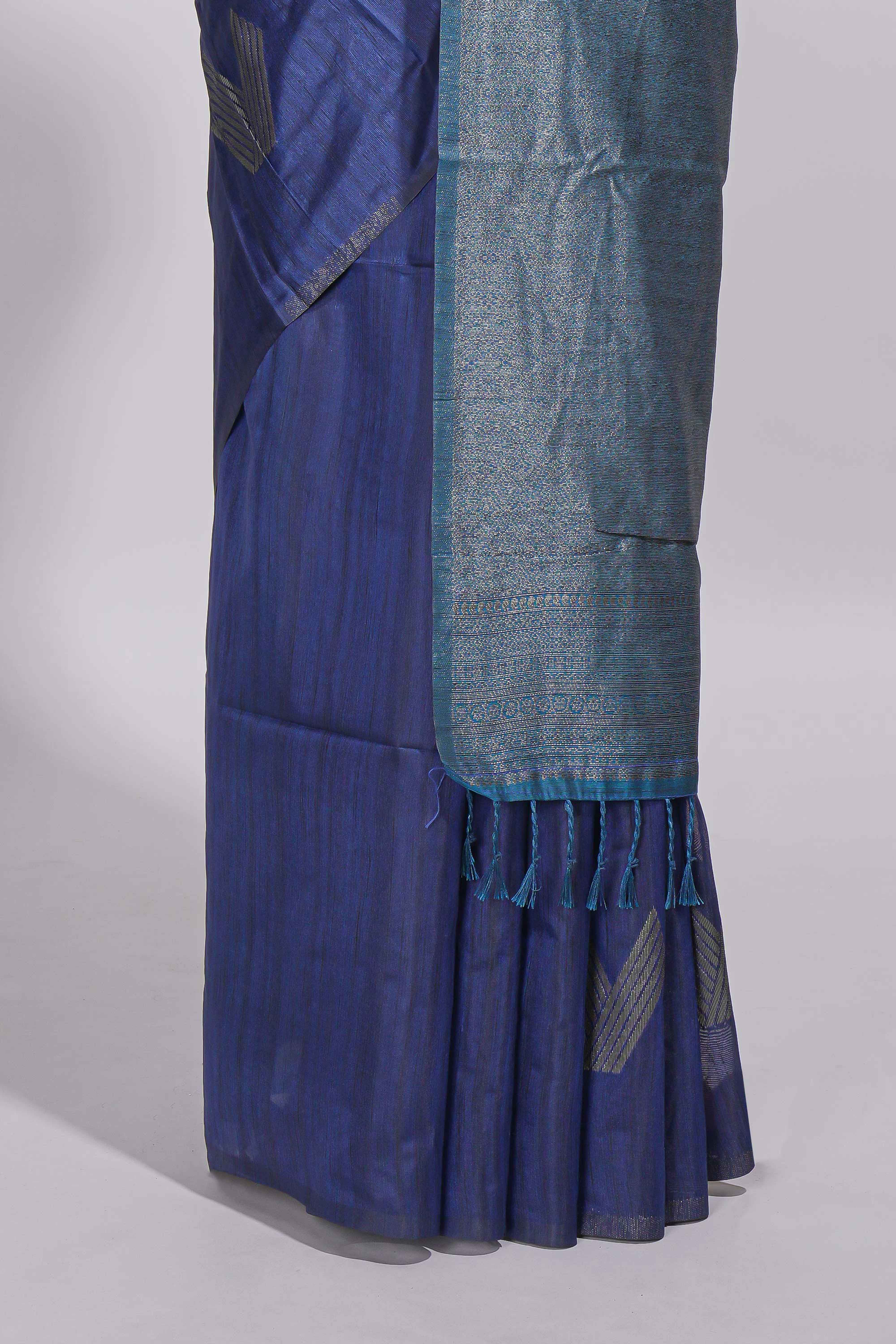 Navy blue tussar saree with subtle silver woven motifs paired with a rich zari pallu with tassels with contrast blouse piece