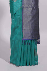 Peacock green tussar saree with subtle silver woven motifs paired with a rich zari pallu with tassels with contrast blouse piece