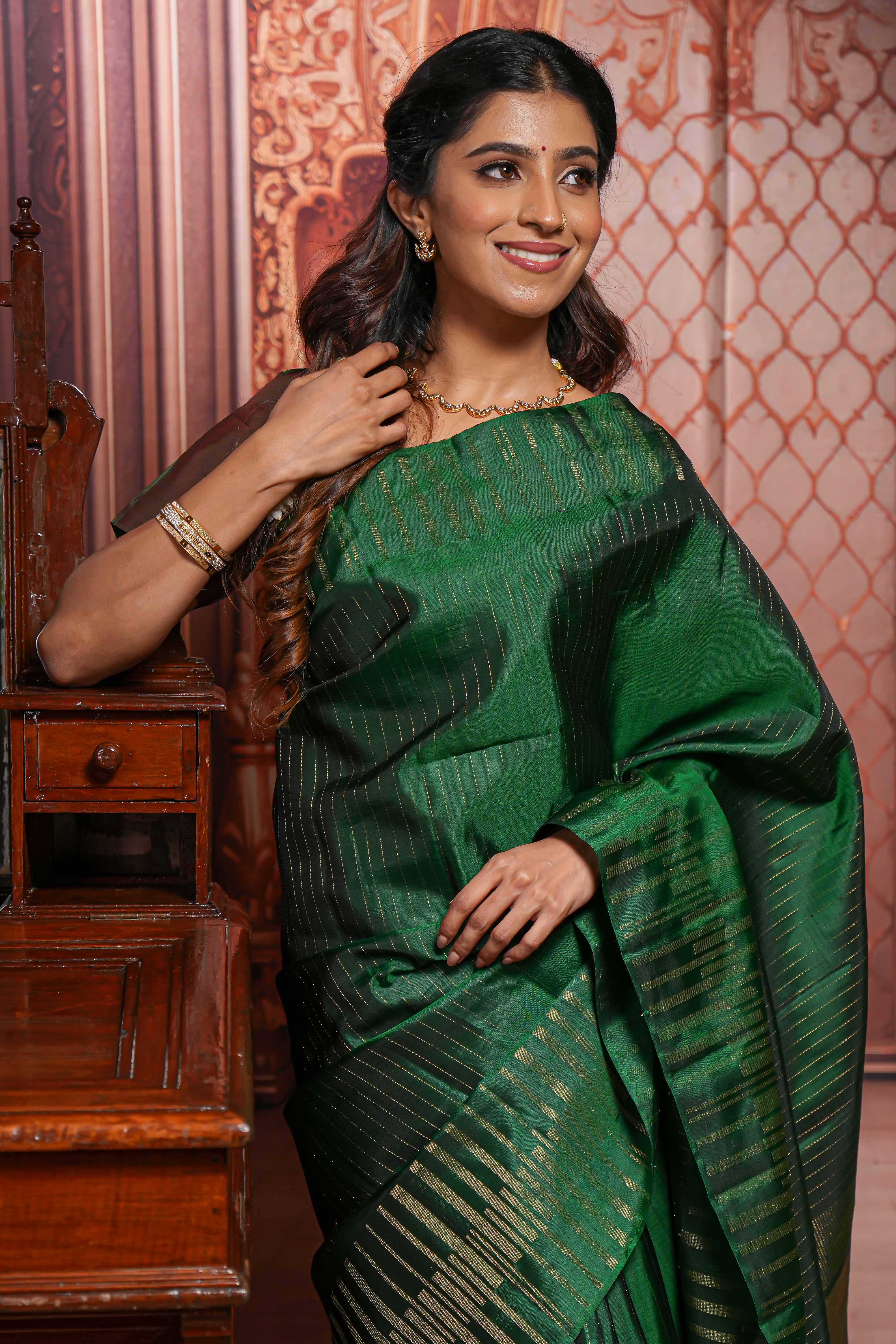 Borderless green parambariya pattu saree with zari stripes and matching checked zari pallu