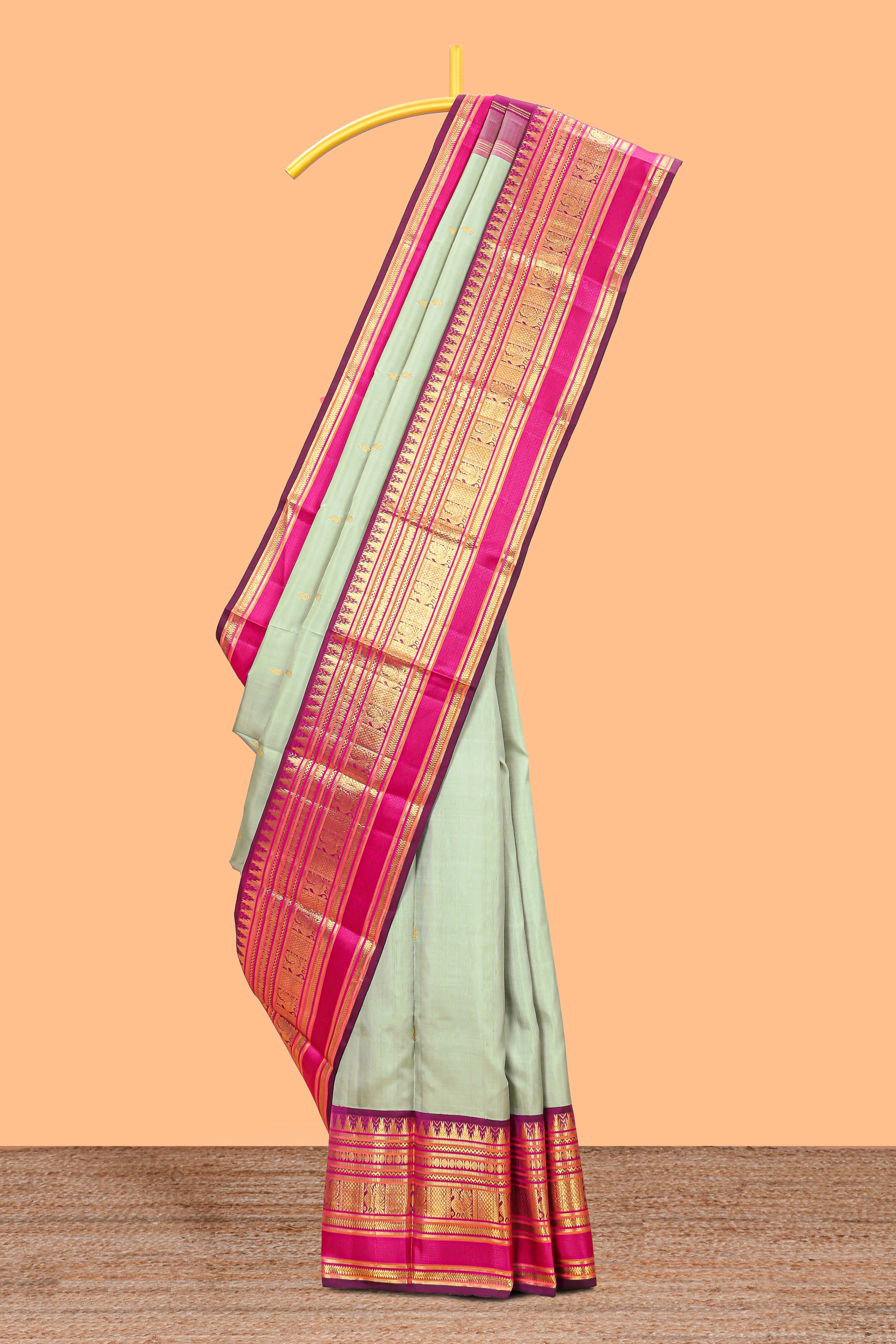 Mint green gold zari butta designed parambariya pattu saree with contrast golden zari border and contrasting pallu beautiful zari design