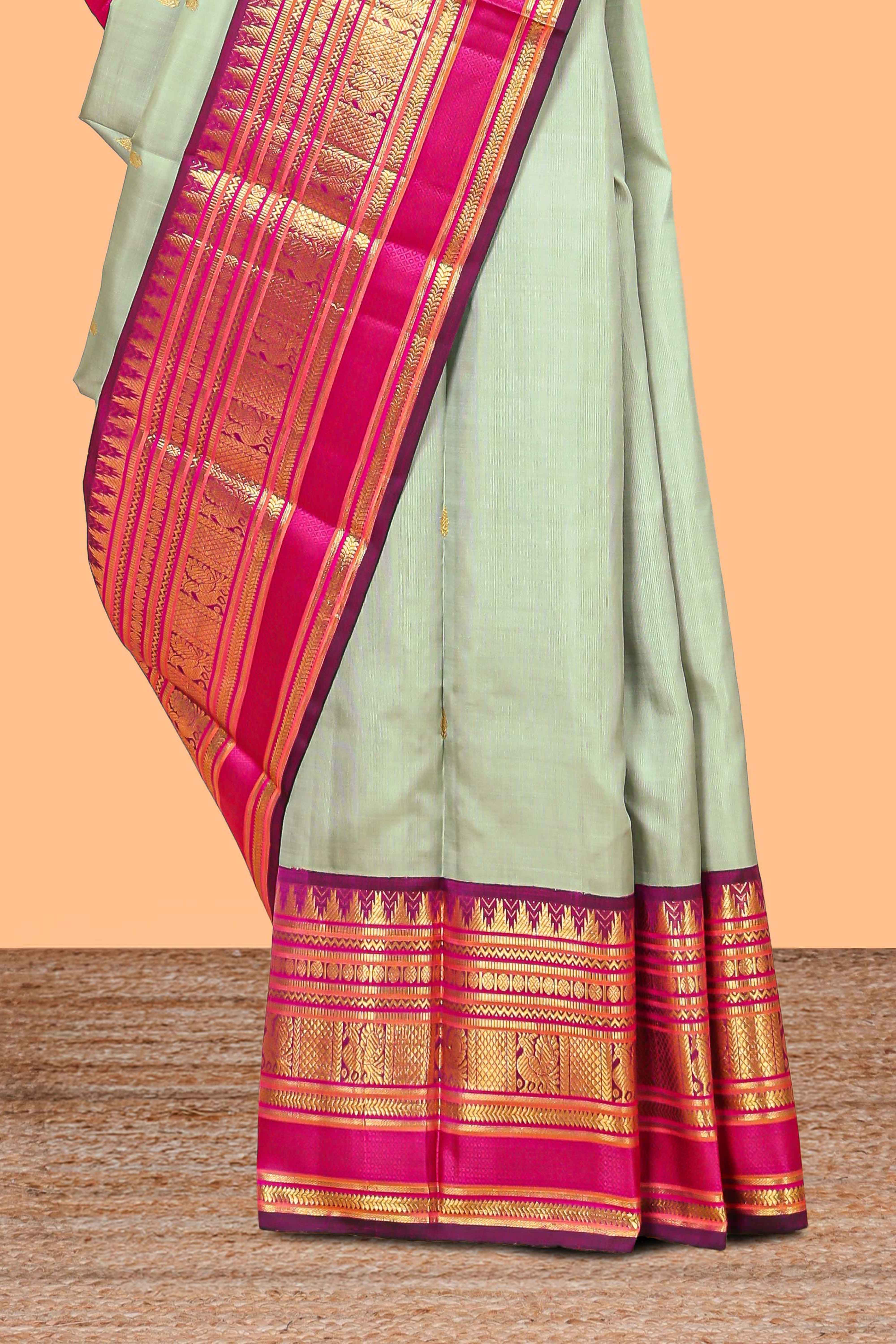 Mint green gold zari butta designed parambariya pattu saree with contrast golden zari border and contrasting pallu beautiful zari design