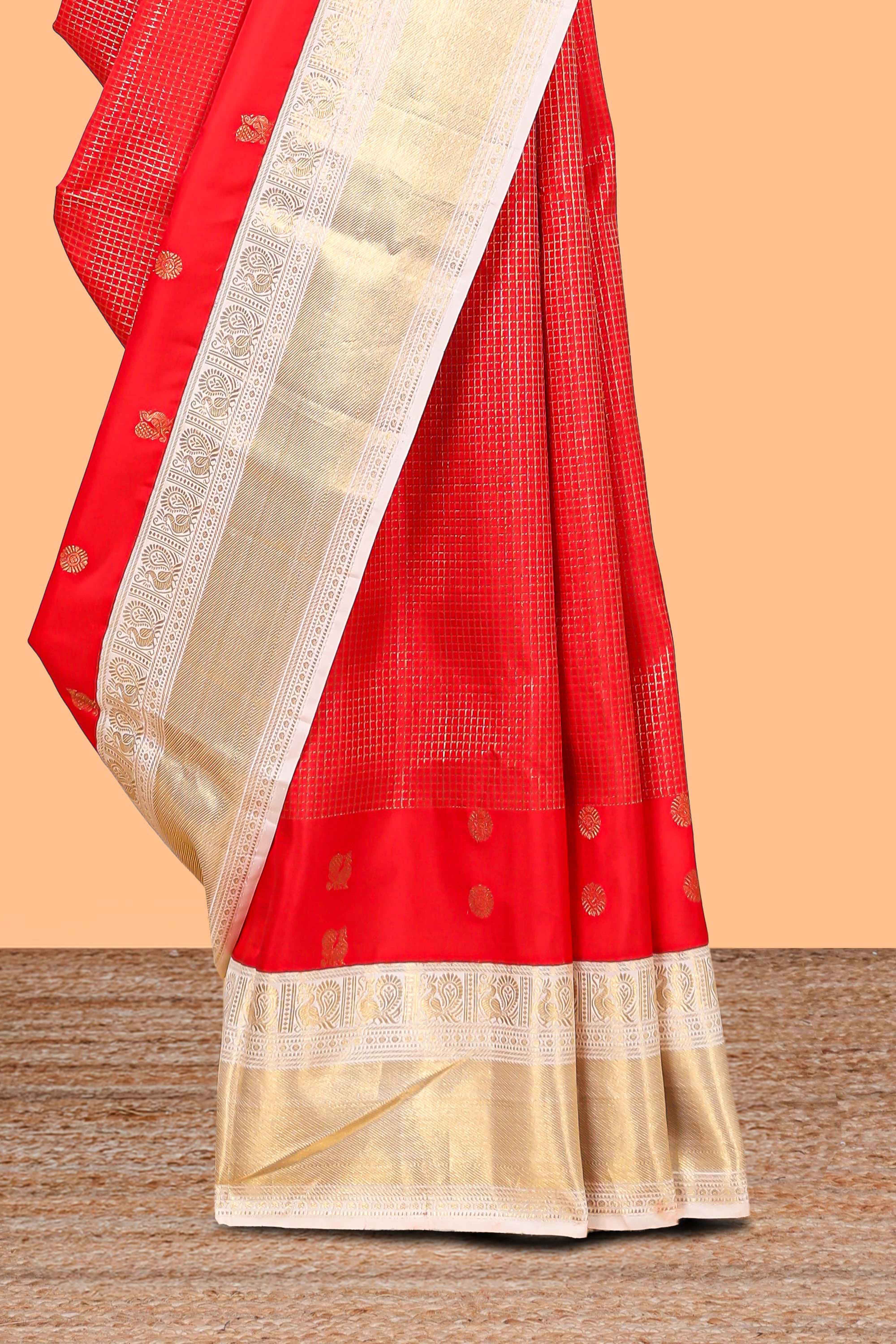 Bright red peacock motifs checked parambariya pattu saree with contrast golden zari border and contrasting pallu designed with geometric patterns and peacock motifs