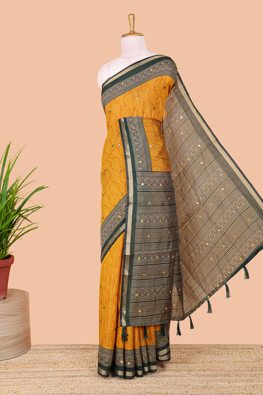 Mustard chanderi cotton saree with all over peacock feather print, mirror work, contrast border and pallu
