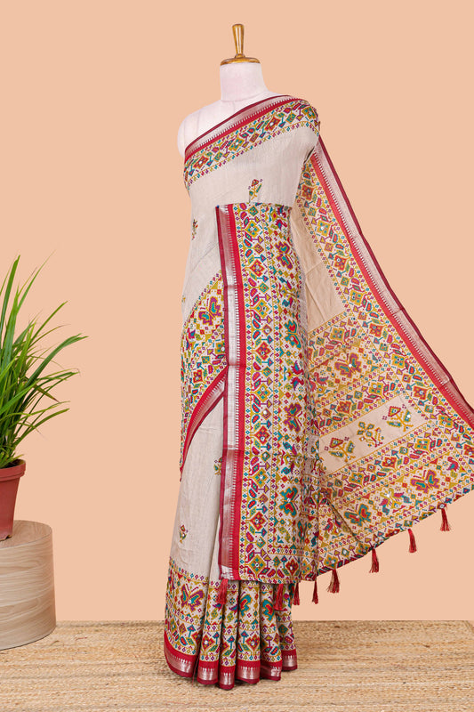 Cream chanderi cotton saree with geometric floral butta, red zari border and patola inspired mirror work