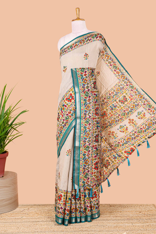 Cream chanderi cotton saree with geometric floral butta, blue zari border and patola inspired mirror work