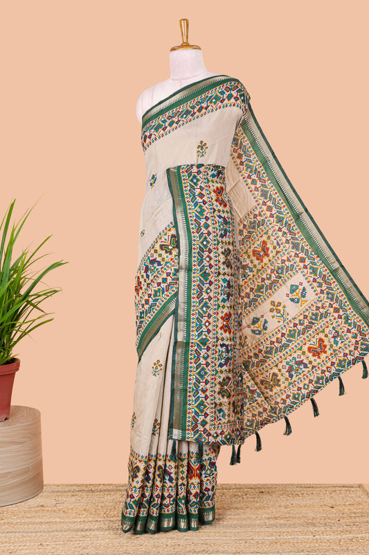Cream chanderi cotton saree with geometric floral butta, green zari border and patola inspired mirror work