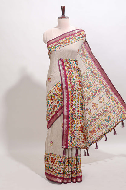 Cream chanderi cotton saree with ikkat style floral butta, pink border and patola inspired mirror work