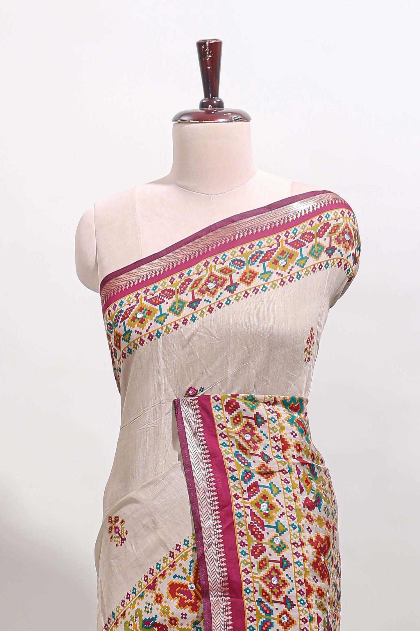 Cream chanderi cotton saree with ikkat style floral butta, pink border and patola inspired mirror work