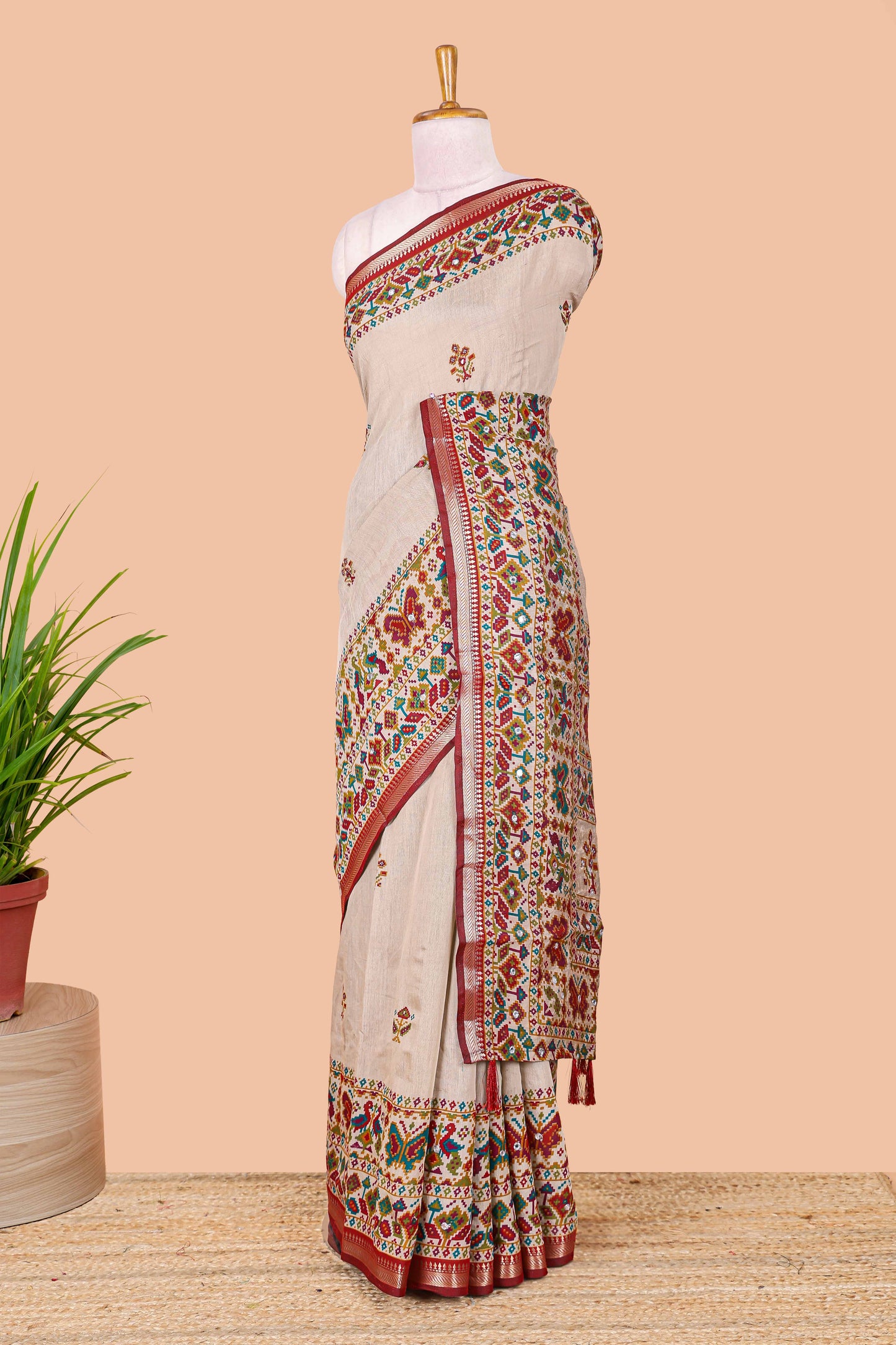 Cream chanderi cotton saree with geometric floral butta, maroon zari border and patola inspired mirror work