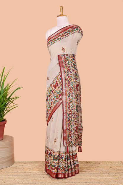 Cream chanderi cotton saree with geometric floral butta, maroon zari border and patola inspired mirror work