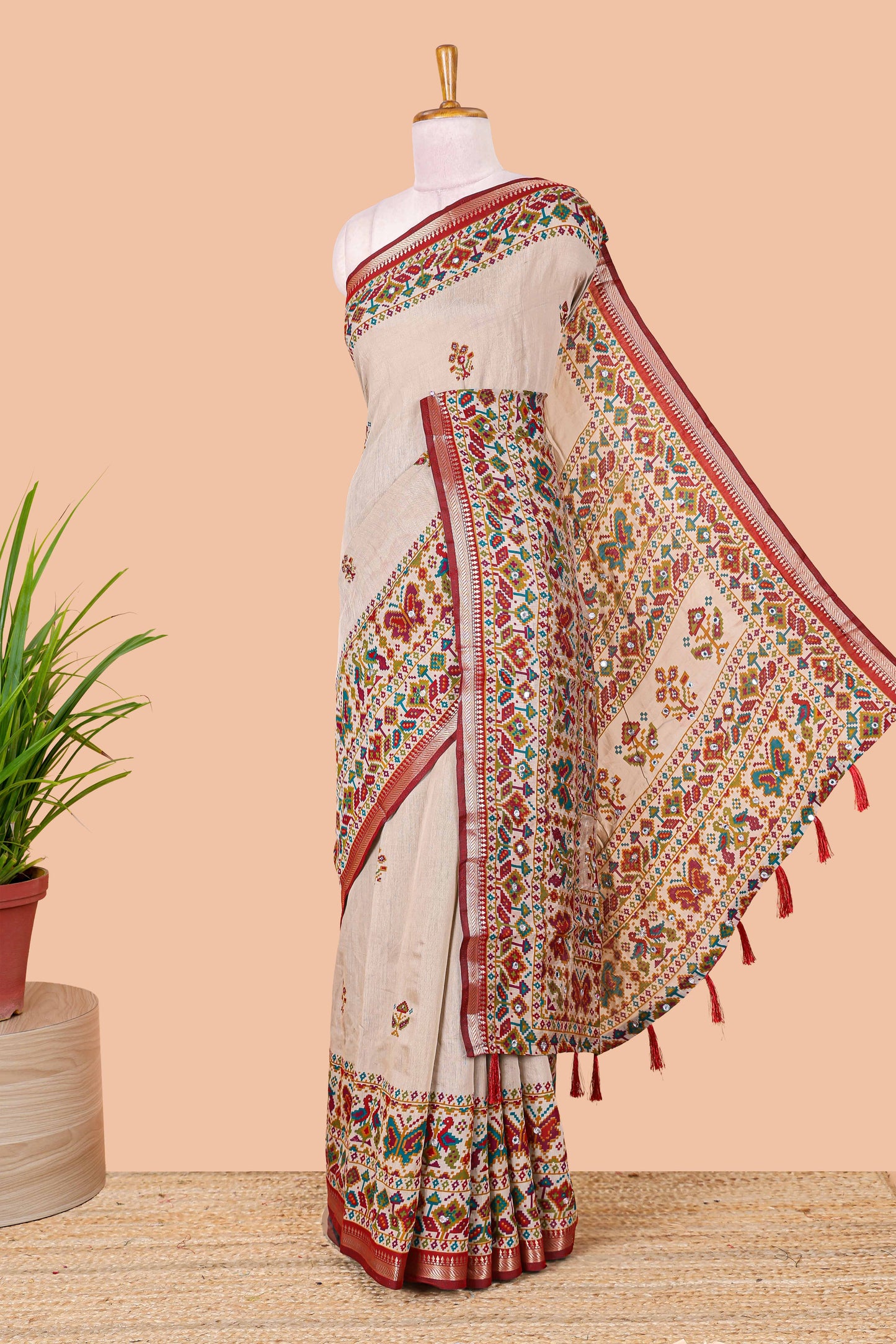 Cream chanderi cotton saree with geometric floral butta, maroon zari border and patola inspired mirror work