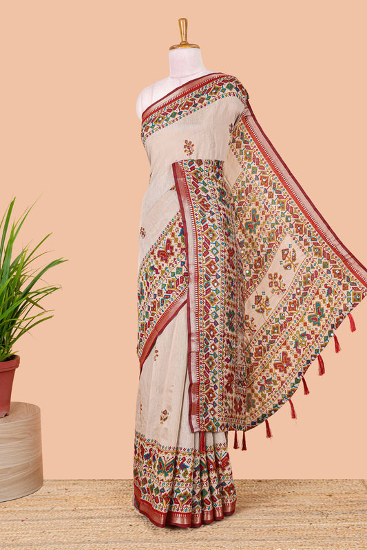Cream chanderi cotton saree with geometric floral butta, maroon zari border and patola inspired mirror work