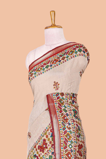 Cream chanderi cotton saree with geometric floral butta, maroon zari border and patola inspired mirror work