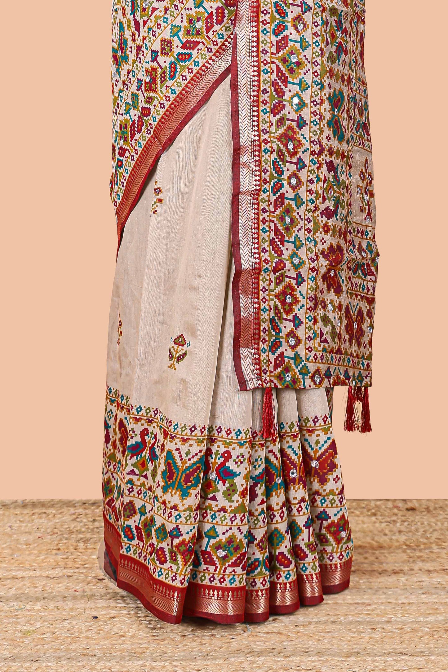 Cream chanderi cotton saree with geometric floral butta, maroon zari border and patola inspired mirror work