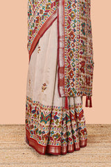 Cream chanderi cotton saree with geometric floral butta, maroon zari border and patola inspired mirror work
