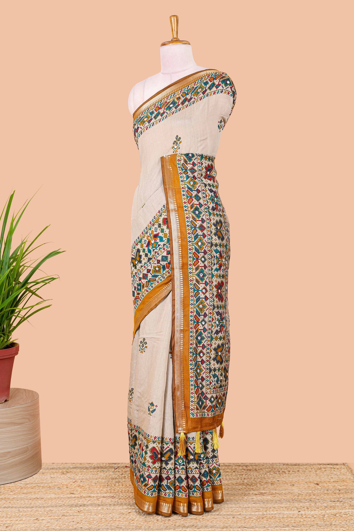 Cream chanderi cotton saree with geometric floral butta, mustard zari border and patola inspired mirror work