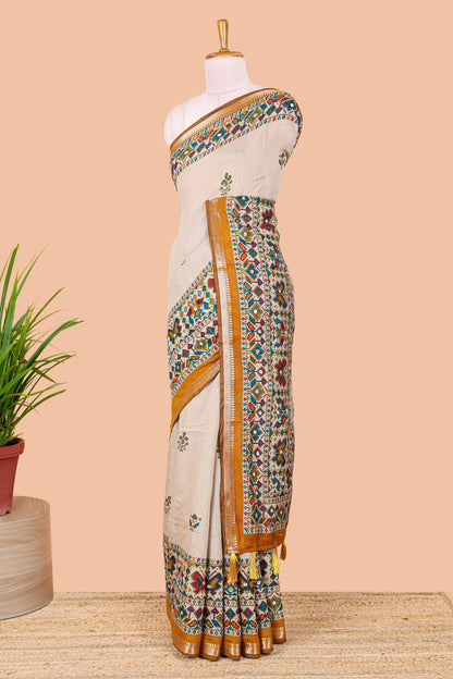 Cream chanderi cotton saree with geometric floral butta, mustard zari border and patola inspired mirror work