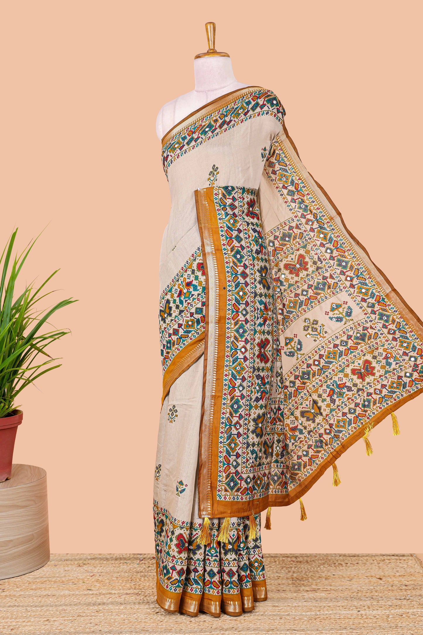 Cream chanderi cotton saree with geometric floral butta, mustard zari border and patola inspired mirror work
