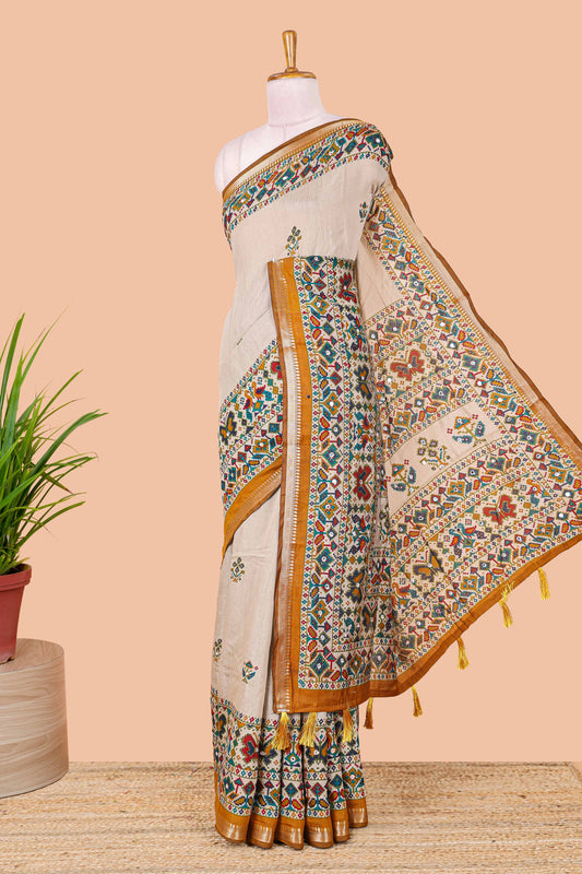 Cream chanderi cotton saree with geometric floral butta, mustard zari border and patola inspired mirror work