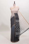 Cream and black dual shade checked checked linen cotton saree with self zari border printed blouse