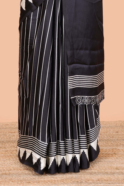 Black satin ajrakh modal printed saree with striped body and geometric print border and pallu