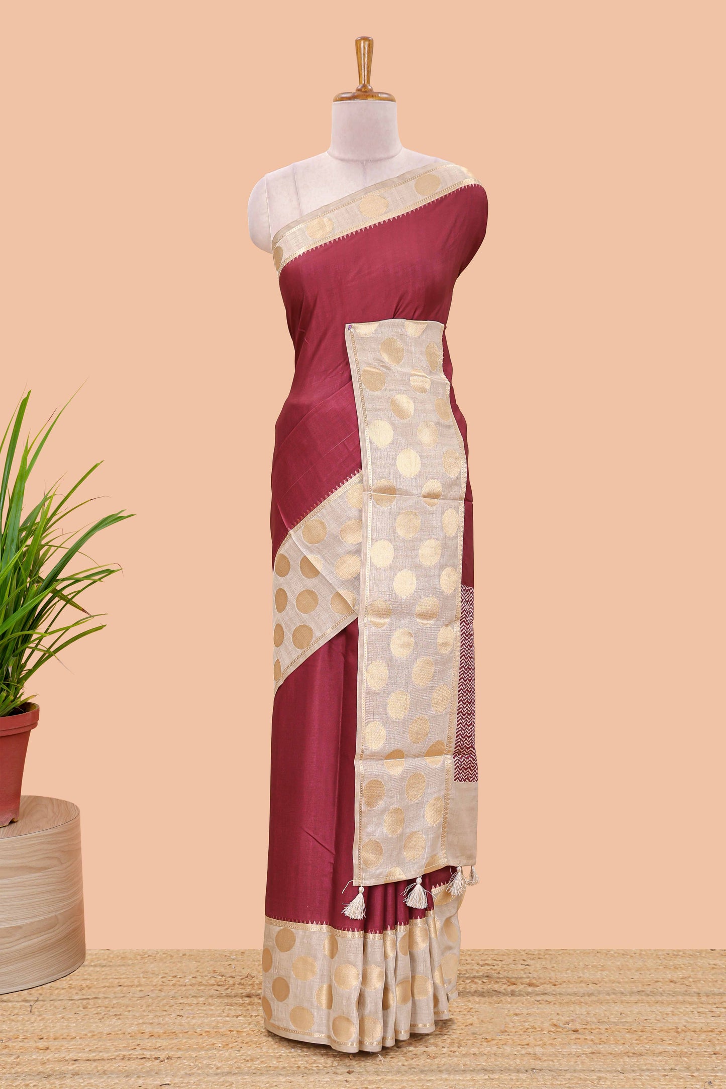 Maroon art tussar saree with plain body, cream coin motif zari border and zig-zag printed pallu