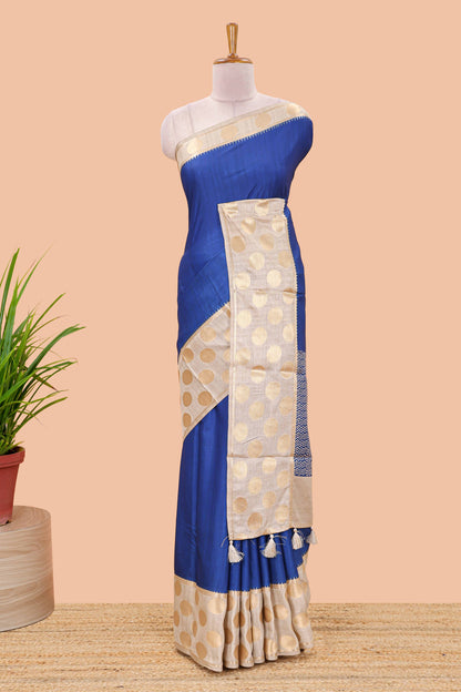 Blue art tussar saree with plain body, cream coin motif zari border and zig-zag printed pallu