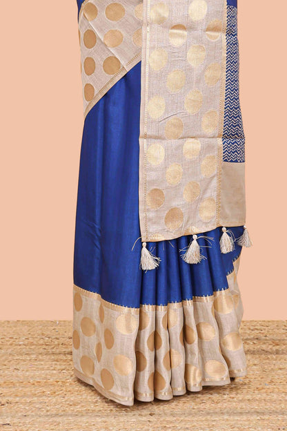 Blue art tussar saree with plain body, cream coin motif zari border and zig-zag printed pallu